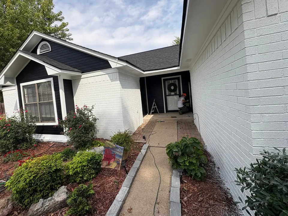 After: the same front walk, white brick and black siding with white trim